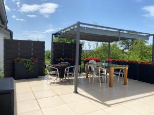 a patio with tables and chairs under a pergola at Apartment CHEZ TONY in Strassen