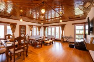 a living room with a wooden ceiling and a table at Blume House- 4BHK Holiday Home with Kitchen & Garden in Srinagar