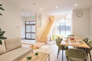 a living room with a table and chairs and a staircase at ぷにるんパーク in Nagoya