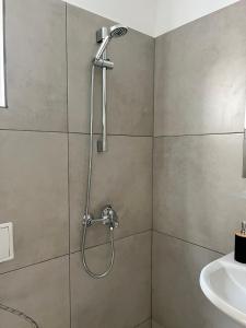 a shower with a shower head in a bathroom at Kъща за гости Христина in Lozenets +81 photos