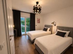 a hotel room with two beds and a chandelier at Garden Haus Livno in Livno