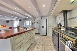 a large kitchen with a stove and a refrigerator at Ty venoux in Elven