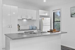a white kitchen with a sink and a refrigerator at Native Retreat - Tranquil Seaham Escape in Seaham