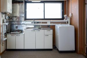a kitchen with a sink and a refrigerator and a window at c Furano A in Furano