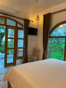 a bedroom with a bed and a large window at Tetebatu Sunset House in Tetebatu +36 photos