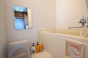 a bathroom with a sink and a toilet and a mirror at c Furano A in Furano