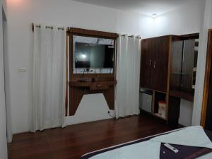 a room with a television and a desk with a mirror at Cross Bill Beach Resort in Havelock Island