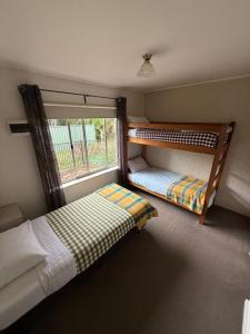 two bunk beds in a room with a window at Restaway Holiday Units in Porepunkah