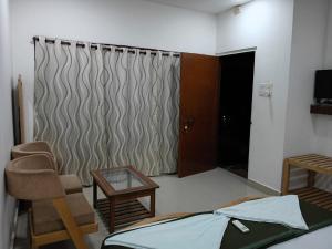 a room with a bed and a door and a table at Cross Bill Beach Resort in Havelock Island +9 photos