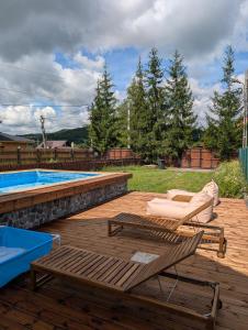 a deck with a pool and a chair and a table at COM Home Sovata in Sovata