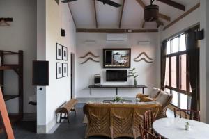 a living room with a table and chairs and a television at Uthai Heritage Hotel in Ban Nong Nam Khan
