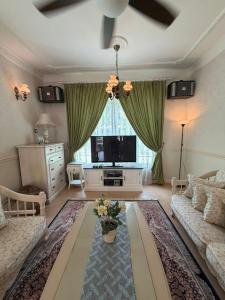 a living room with a couch and a tv at Green Homestay in Nilai
