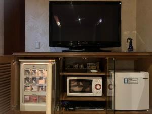 a tv sitting on top of a shelf with a microwave at Hulamoon in Maizuru +20 photos