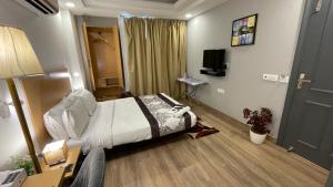 a hotel room with a bed and a television at Saltstayz Express - Golf Course Road & DLF Phase-1 in Gurgaon