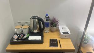 a table with a coffee maker and a tea kettle at Saltstayz Express - Golf Course Road & DLF Phase-1 in Gurgaon