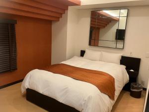 a bedroom with a large bed with a large mirror at Hulamoon in Maizuru