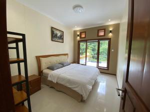 a bedroom with a bed and a large window at Villa New IMS in Bandung +24 photos