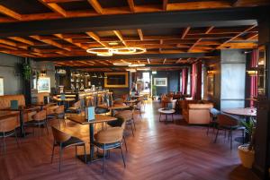 a restaurant with tables and chairs and a bar at Ramada by Wyndham Cheltenham in Cheltenham