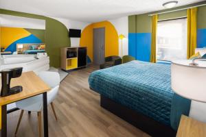 a hotel room with a bed and a bathroom at Days Inn By Wyndham Pigeon Forge South in Pigeon Forge