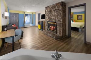 a living room with a fireplace and a bedroom at Days Inn By Wyndham Pigeon Forge South in Pigeon Forge