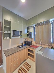 a kitchen with a counter and a refrigerator at Aqua blue bay villa in Covelong