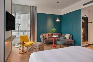 a hotel room with a bed and a couch at Caption by Hyatt Zhongshan Park Shanghai in Shanghai