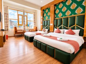 two beds in a room with green walls at Gulmarg GS Residency Hotel in Gulmarg