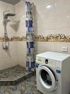 a washing machine in a bathroom with a shower at Jafaridzeebtan in Oni