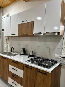 a kitchen with a stove top and white cabinets at Jafaridzeebtan in Oni +3 photos