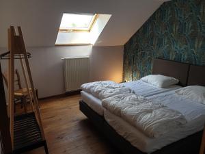 a bedroom with a bed and a ladder and a window at Le basecamp des sommets in Stavelot