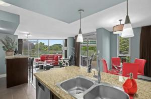 a kitchen with a sink and a living room at Modern 2BR Luxury Apartment - Amazing Location, Steps To Everything! in Vancouver