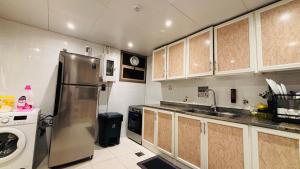 a kitchen with a stainless steel refrigerator and a dishwasher at Haven Hub in Abu Dhabi