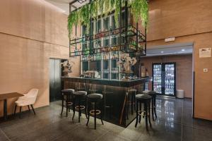 a bar in a restaurant with stools and a shelf with wine glasses at The Venice Times Hotel, Vignette Collection by IHG in Venice