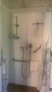 a bathroom with a shower with towels and a shower curtain at Strandlust Döbeln - Bungalow für eine gemütliche Auszeit zu jeder Jahreszeit in Döbeln +26 photos