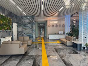 a lobby with couches and a yellow line on the floor at Wind Rose in Almaty