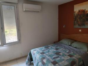 a bedroom with a bed and a window at Hotel Le Bois Des Espeisses in Nîmes