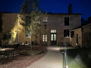 a building with a courtyard with tables and a tree at La Maison du 19 in Cluny