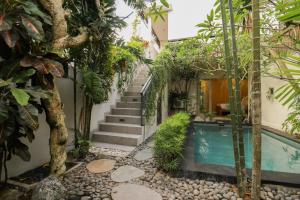 a house with a swimming pool and a staircase at Neduh House Pererenan in Pererenan