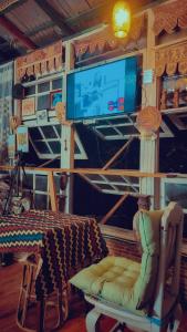 a living room with a tv and a chair and a table at Slove U House in Khon Kaen