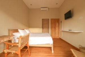 a bedroom with a bed and a table and chairs at Neduh House Pererenan in Pererenan