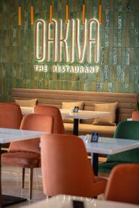 a restaurant with tables and chairs and a sign that reads carolina the restaurant at Fraser Suites Muscat in Muscat