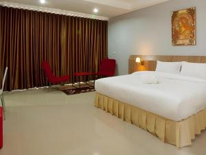 a bedroom with a large bed and two red chairs at Soontree House Hotel in Udon Thani +29 photos