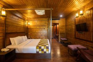 a bedroom with a bed in a wooden cabin at TSG Aura in Neil Island