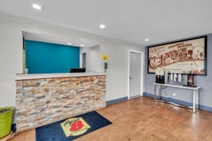 a living room with a fireplace and a large screen at Super 8 by Wyndham Warner Robins in Warner Robins