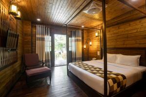 a bedroom with a bed and a chair in a room at TSG Aura in Neil Island