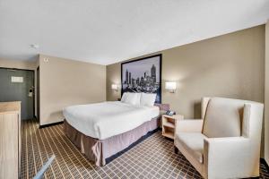 a hotel room with a bed and a chair at Super 8 by Wyndham Warner Robins in Warner Robins