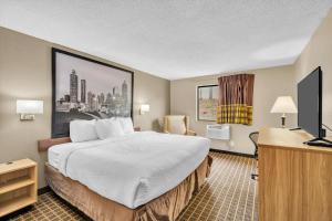 a hotel room with a bed and a television at Super 8 by Wyndham Warner Robins in Warner Robins