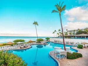 an image of a resort pool with palm trees and the ocean at Hyatt Regency Maui Resort & Spa in Lahaina