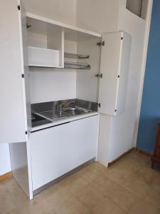 a kitchen with white cabinets and a sink at Antica Residenza in Perdifumo