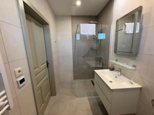 a white bathroom with a sink and a shower at Levendula Apartman in Buzsák +18 photos